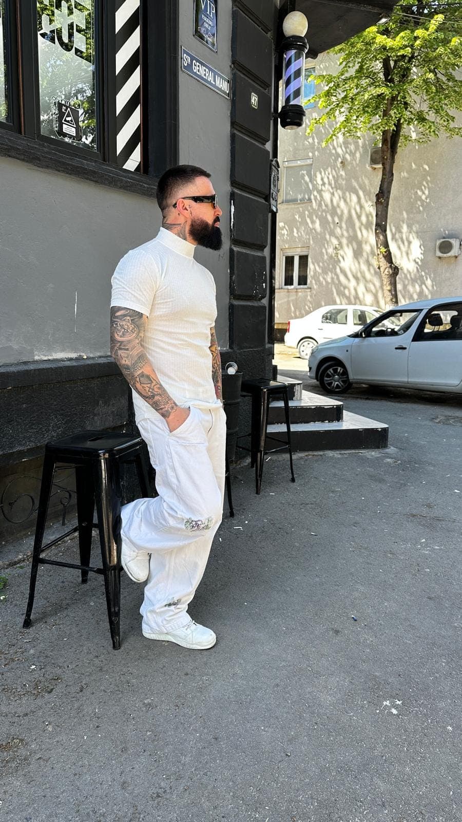 Juliano în ținută albă în fața barbershop-ului pe Strada General Manu