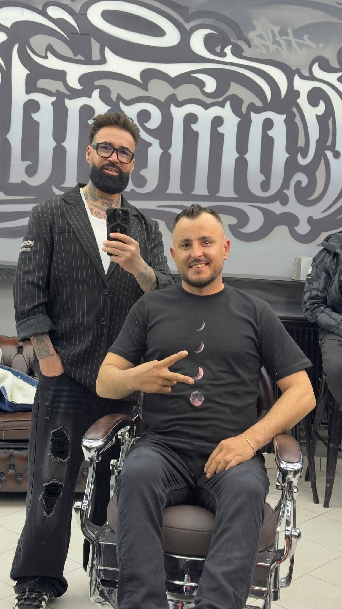 Juliano și client în fața muralului El Comandante — tunsoare activă