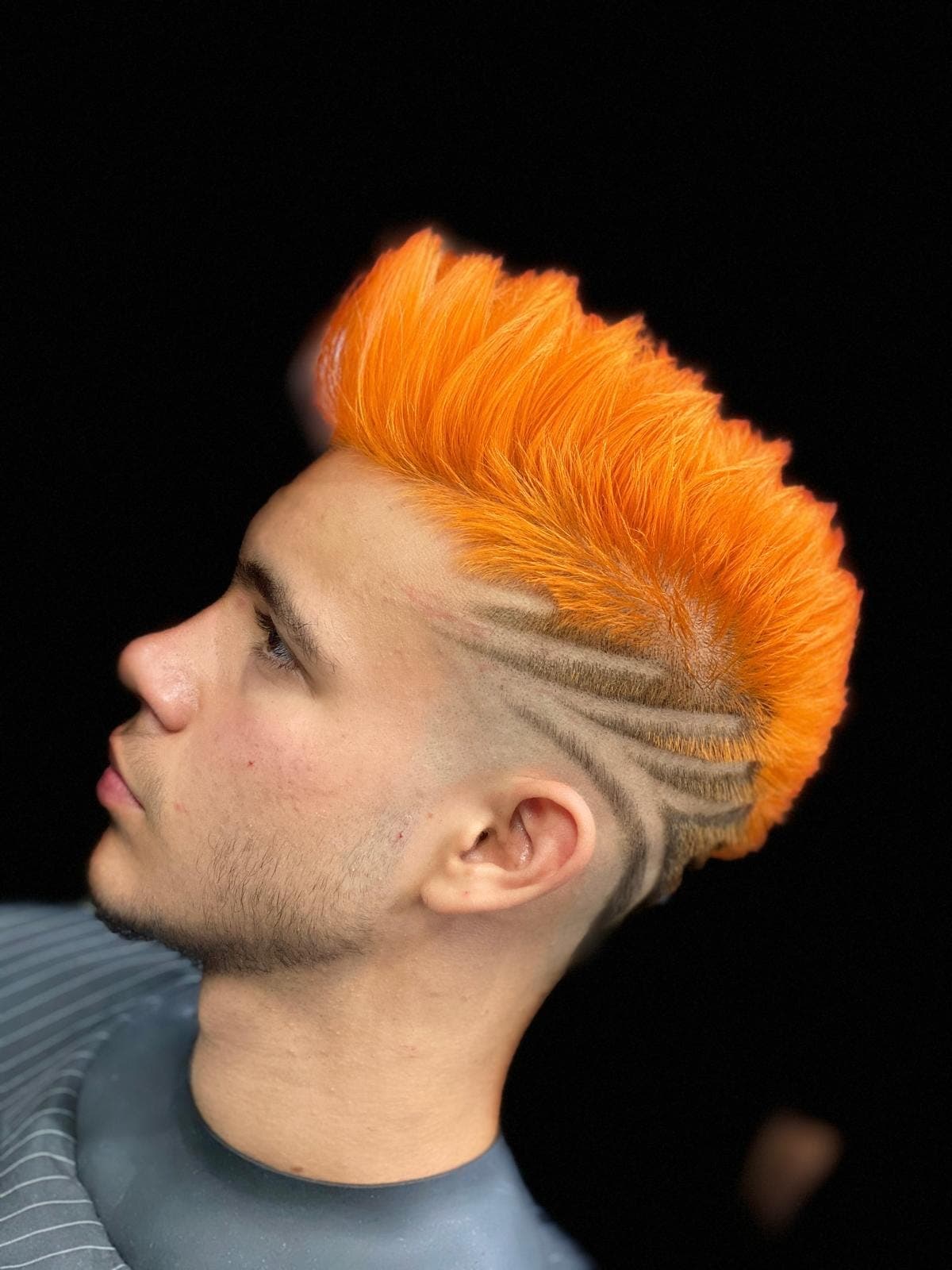 Mohawk portocaliu dramatic pe fond negru cu design ras în fade